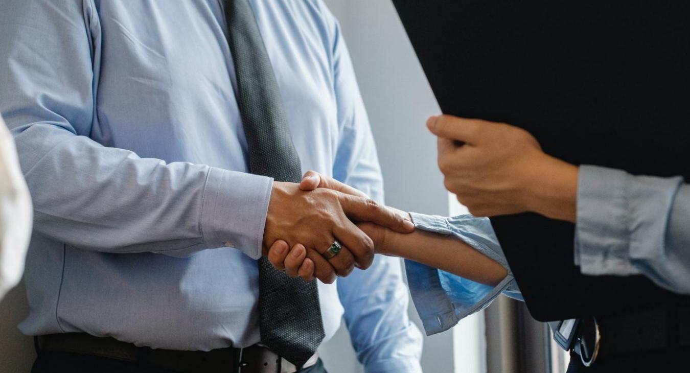 management and worker shake hands